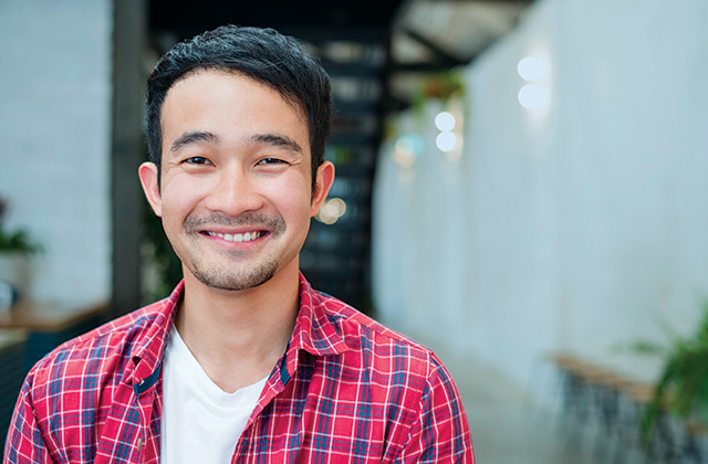 Happy employee smiling at camera in bright, modern office setting