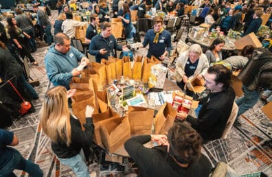 Sound staff gathered around a table to prepare meal kits.