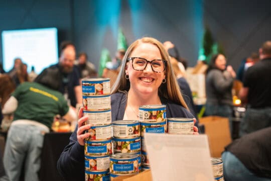 Sound employee, Tawni, holding canned food.