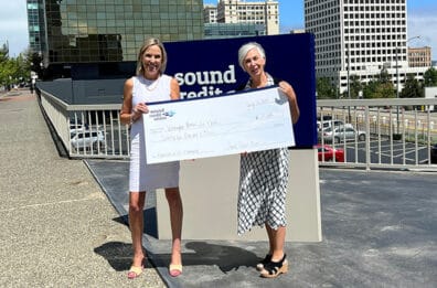 Sound's VP of PR presenting Washington Women in Need with a donation check.