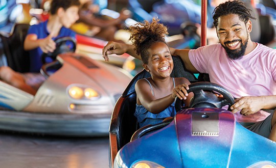 father and daughter in bumper cars