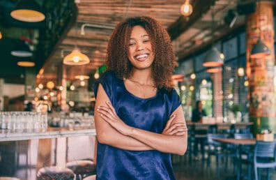 A confident, happy woman standing with arms crossed.