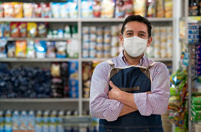 Small business owner in shop wearing a mask
