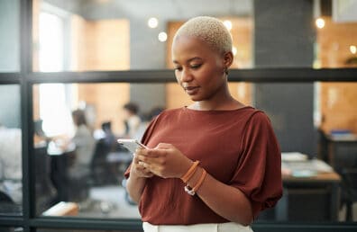 A women cautiously checking their phone.