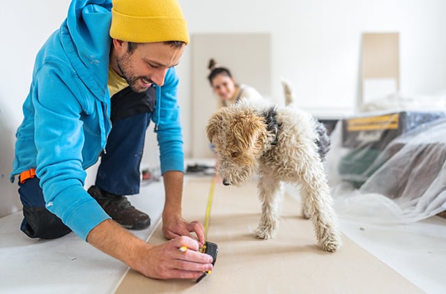 Couple working on home improvements with dog