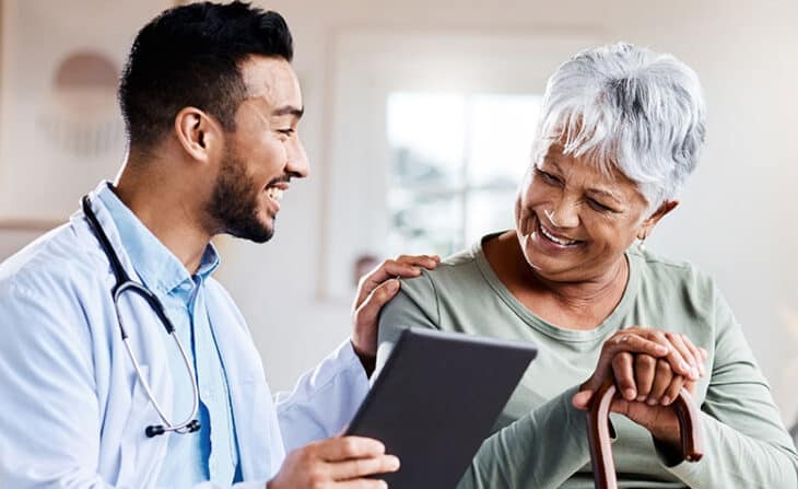 Middle aged woman with cane in primary care clinic with physician
