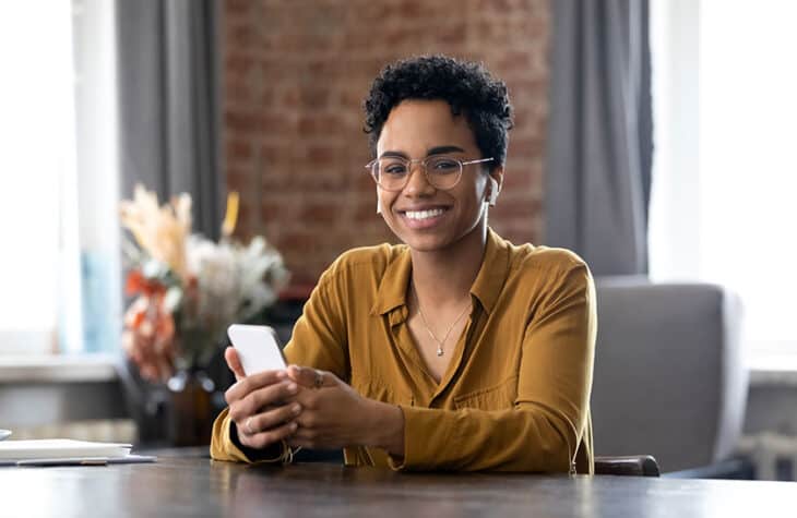 business woman in eyeglasses holding mobile phone