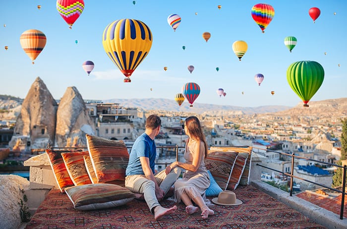 couple during sunrise watching hot air balloons in Cappadocia, Turkey