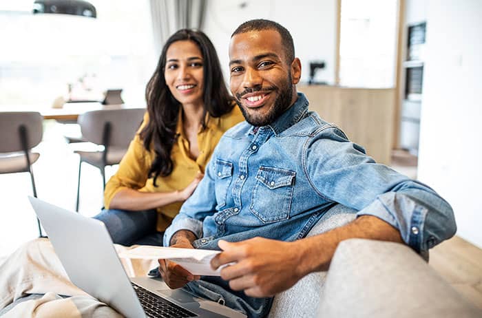 Young couple planning their finances together at home in living room