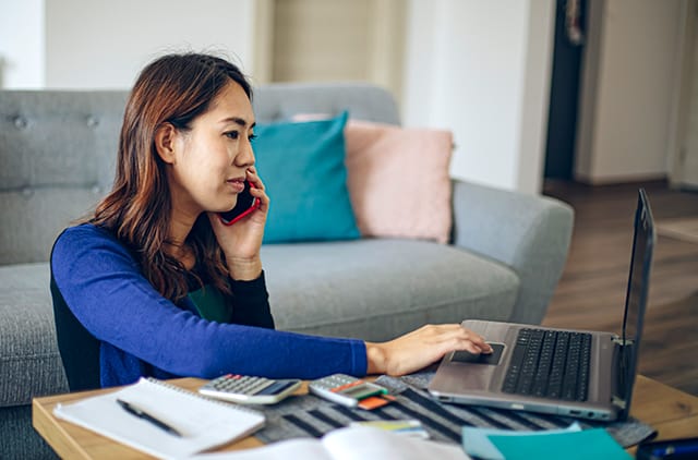 Member talking on phone and looking at laptop screen