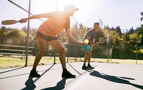 Couple playing pickleball on summer morning