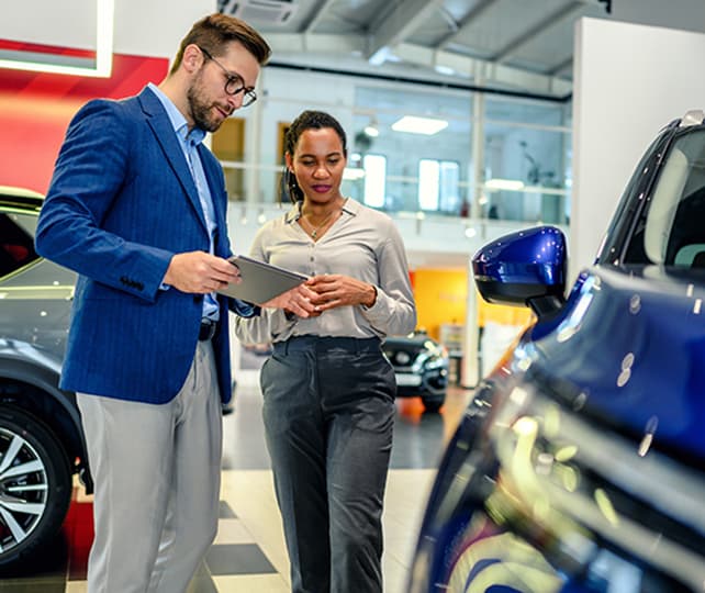 shopping for a new car on showroom floor with salesperson