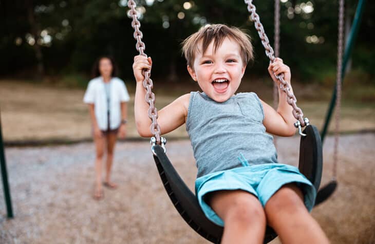 Toddler Laughing on Playground Swing
