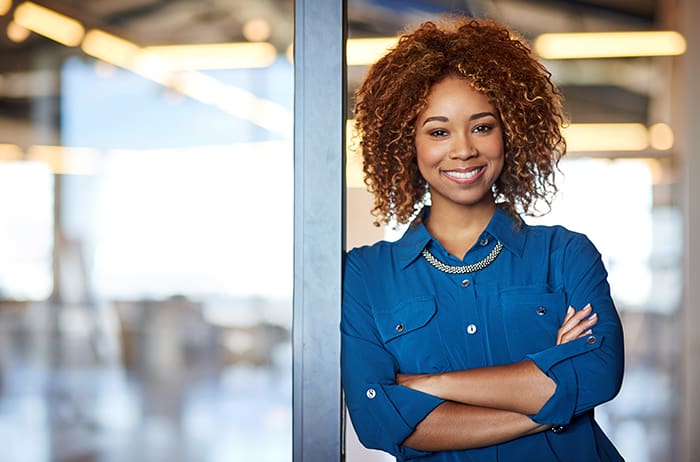 Professional woman smiling in office doorway