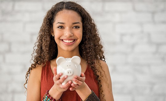 holding a piggy bank and smiling